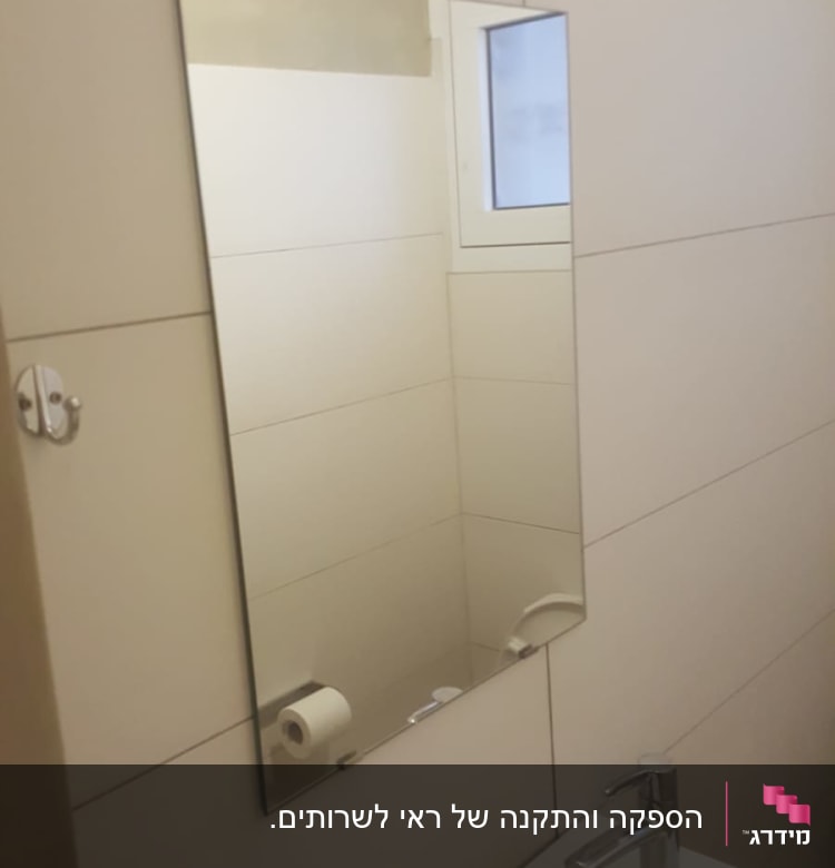 מראה מלבנית תלויה על קיר חדר אמבטיה